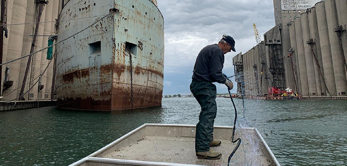 A man on a boat holding a net.